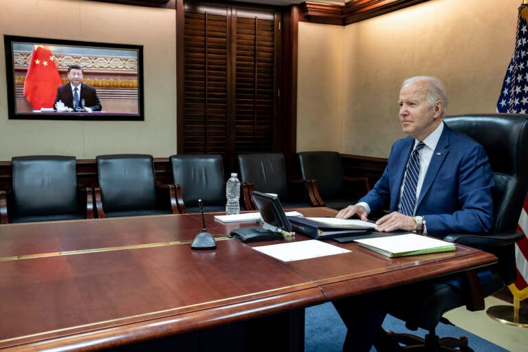 In this image provided by the White House, President Joe Biden meets virtually from the Situation Room at the White House with China’s Xi Jinping, Friday, March 18, 2022, in Washington