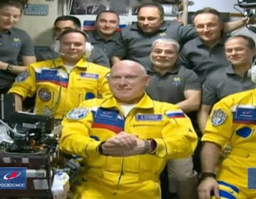 In this frame grab from video provided by Roscosmos, Russian cosmonauts Sergey Korsakov, Oleg Artemyev and Denis Matveyev are seen during a welcome ceremony after arriving at the International Space Station, Friday, March 18, 2022, the first new faces in space since the start of Russia’s war in Ukraine. The crew emerged from the Soyuz capsule wearing yellow flight suits with blue stripes, the colors of the Ukrainian flag