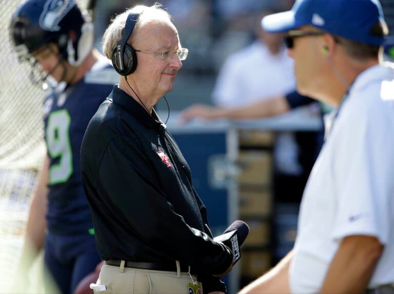 John ''The Professor'' Clayton, an NFL football writer and reporter for ESPN, stands on the sideline during an NFL football game between the Seattle Seahawks and the San Francisco 49ers, Sunday, Sept. 25, 2016, in Seattle. (AP Photo/Ted S. Warren)