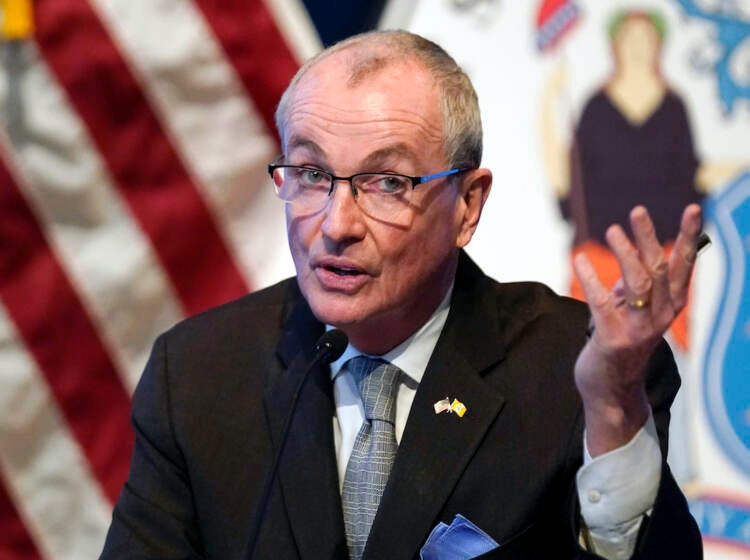 New Jersey Governor Phil Murphy speaks in front of an American flag.