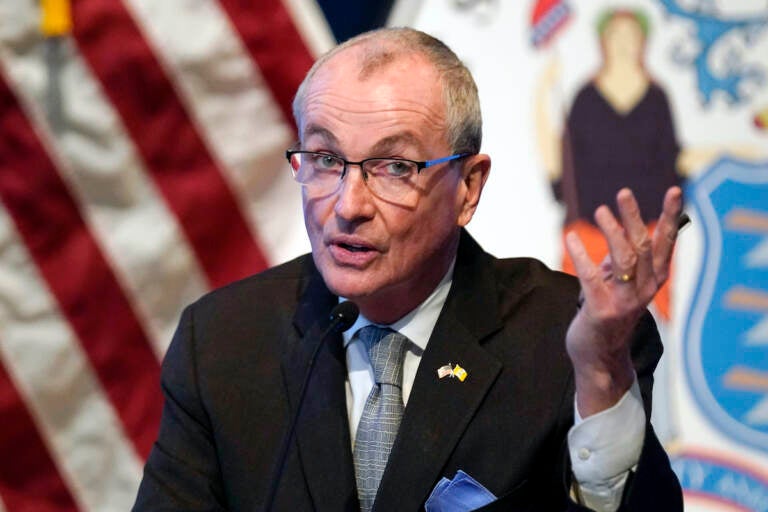 New Jersey Governor Phil Murphy speaks in front of an American flag.