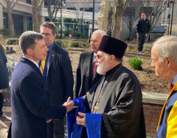 State leaders join Ukrainian ministers and U.S. Sec. of Transportation Pete Buttigieg raising the flag of Ukraine in Freedom Plaza in downtown Wilmington. (Mark Eichmann/WHYY)