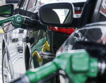 Nozzles pumping gas into cars at a gas station