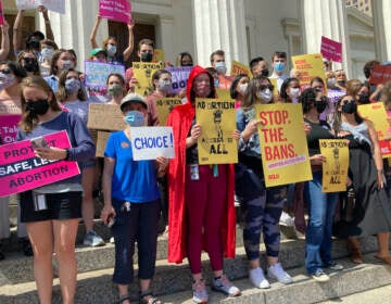 Abortion rights protesters gather outside a courthouse holding signs