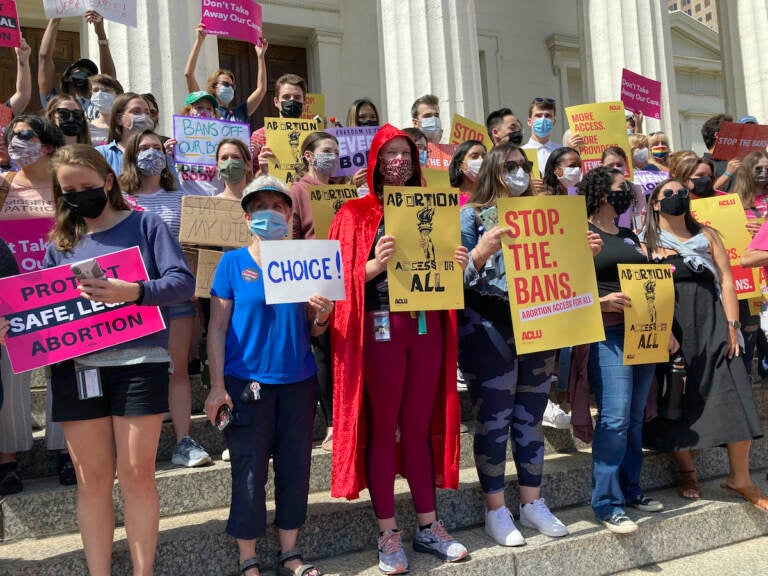 Abortion rights protesters gather outside a courthouse holding signs