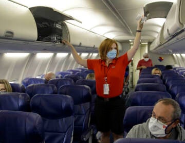 In this 2020 file photo, a Southwest Airlines flight attendant prepares a plane bound for takeoff at the Kansas City International airport in Kansas City, Mo. (Charlie Riedel/AP)