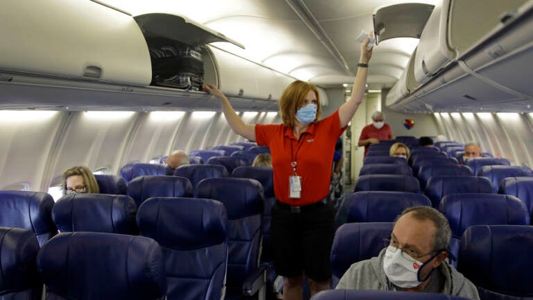 In this 2020 file photo, a Southwest Airlines flight attendant prepares a plane bound for takeoff at the Kansas City International airport in Kansas City, Mo. (Charlie Riedel/AP)