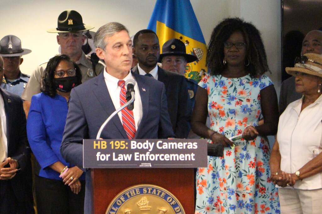 Gov. John Gov. Carney speaks at the podium after he signed the legislation requiring police body cameras statewide more than eight months ago.