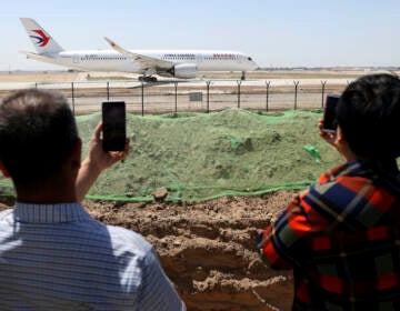 Residents watch as a China Eastern passenger jet prepares to take off