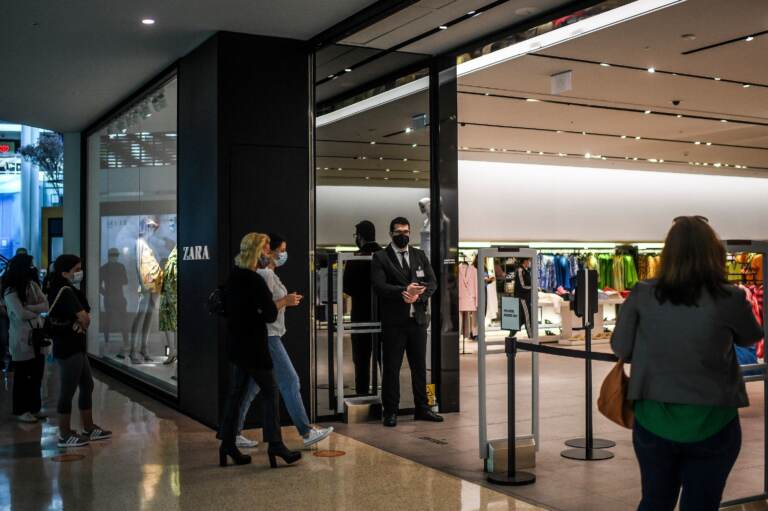 Customers queue to enter a re-opened Zara