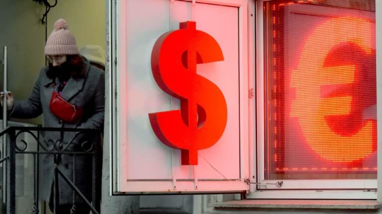 A woman leaves a currency exchange office in Saint Petersburg, Russia, on Wednesday. Russian authorities are scrambling to stem panic as massive sanctions over Moscow's invasion of Ukraine are delivering Russia's worst economic shocks since the fall of the Soviet Union. (Olga Maltseva/AFP via Getty Images)