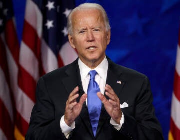 President Biden is speaking in front of an American flag.