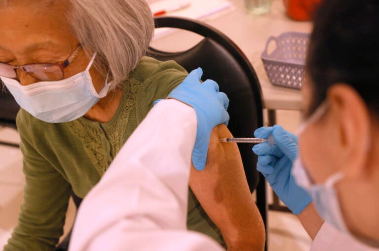A health worker administers a COVID-19 vaccine shot