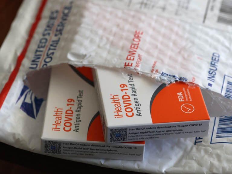 In this photo illustration, free iHealth COVID-19 antigen rapid tests from the federal government sit on a U.S. Postal Service envelope after being delivered on Feb. 4, 2022. (Justin Sullivan/Getty Images)