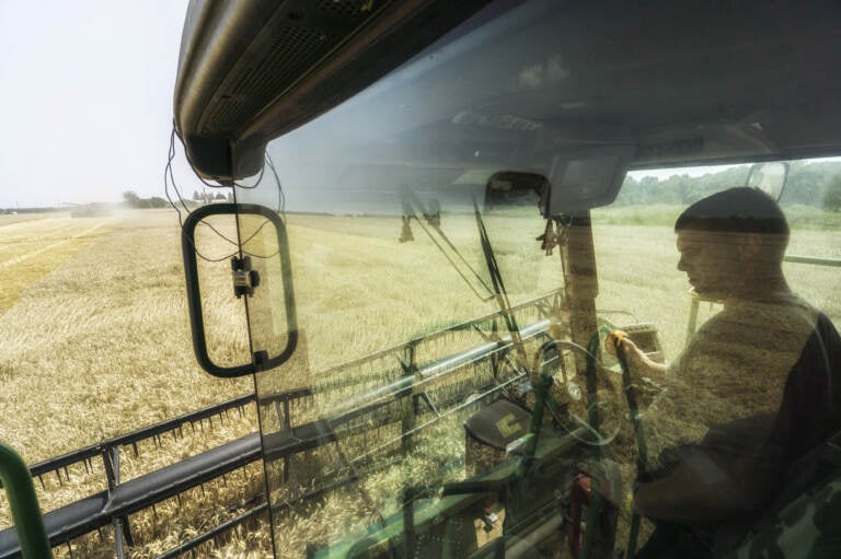 A driver sits in the cab of a combine harvester during the summer harvest in a field of wheat in Varva, Ukraine. Ukraine accounts for more than 10% of the global wheat market. Russia's war threatens to disrupt the spring planting season. (Vincent Mundy/Bloomberg via Getty Images)