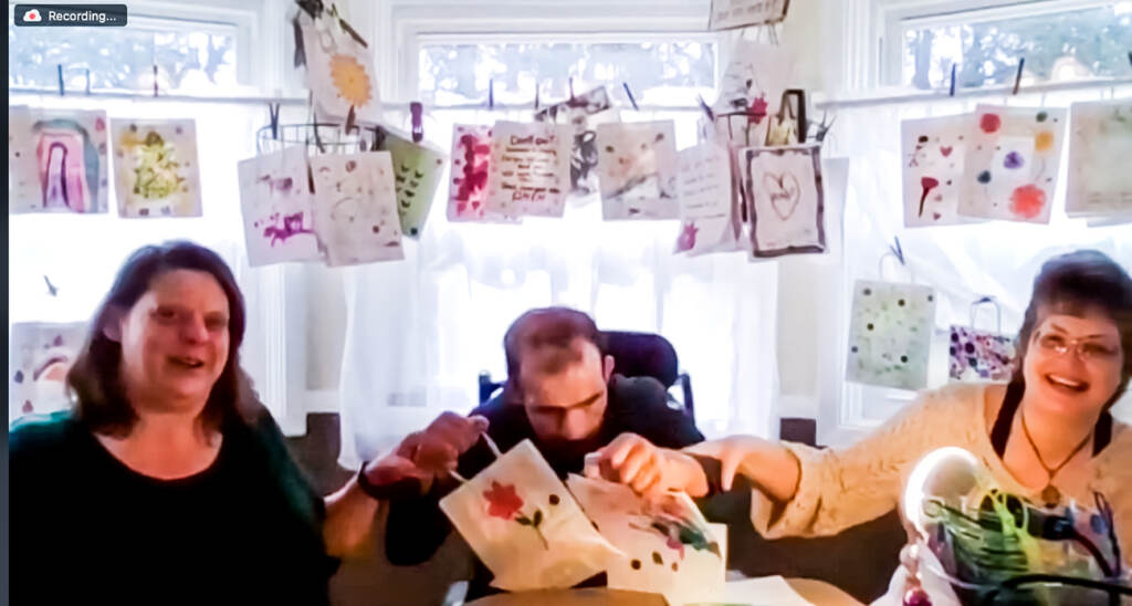 Shannon Watson (left), Steven Abi Richa (center), and Ann Kirk (right) decorating and filling "Steven's Bags" with some decorated and finished bags hanging in the background behind them