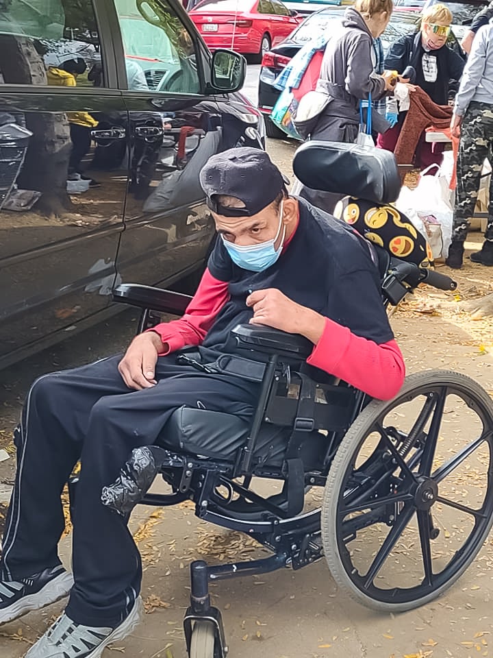 Steven Abi Richa in his wheelchair outside in Kensington helping to hand out "Steven's Bags"