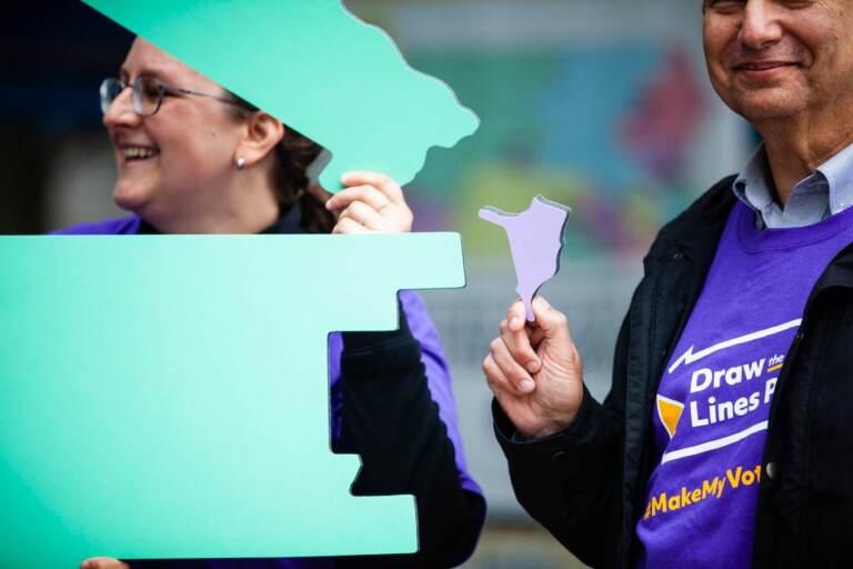 Two people are shown holding pieces of a map of Pennsylvania.