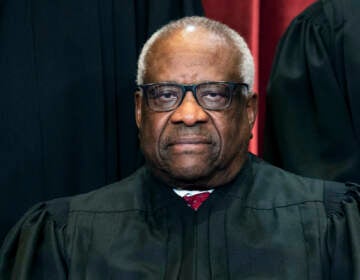 Associate Justice Clarence Thomas sits during a group photo