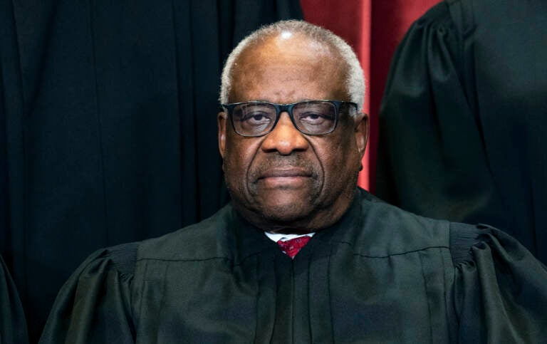 Associate Justice Clarence Thomas sits during a group photo