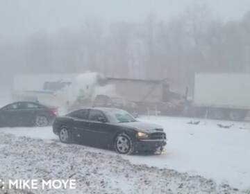 Car crash on snowy highway is shown.