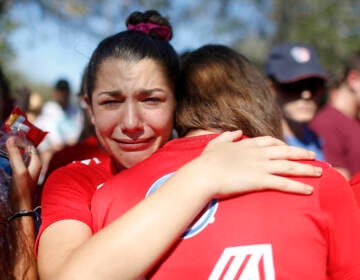 File photo: A student mourns the loss of her friend during a community vigil at Pine Trails Park, Thursday, Feb. 15, 2018, in Parkland, Fla., for the victims of the shooting at Marjory Stoneman Douglas High School. She is crying as she embraces someone.