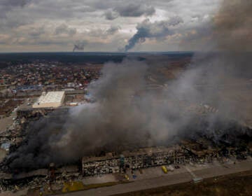 A factory and a store are burning after being bombarded in Irpin