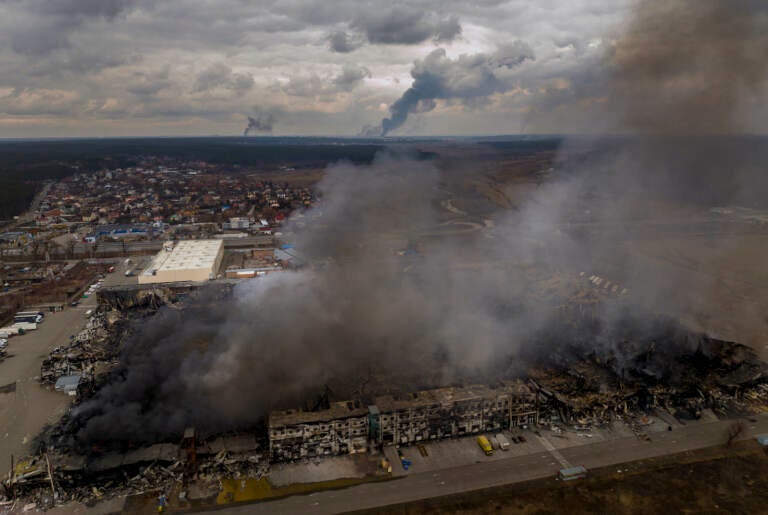 A factory and a store are burning after being bombarded in Irpin