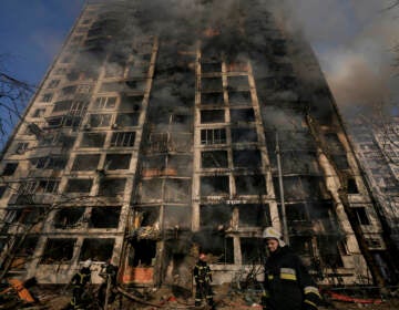 Firefighters work outside a destroyed apartment building after a bombing in a residential area in Kyiv