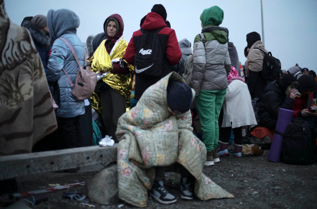 Refugees, mostly women and children, wait in a crowd for transport after fleeing from Ukraine