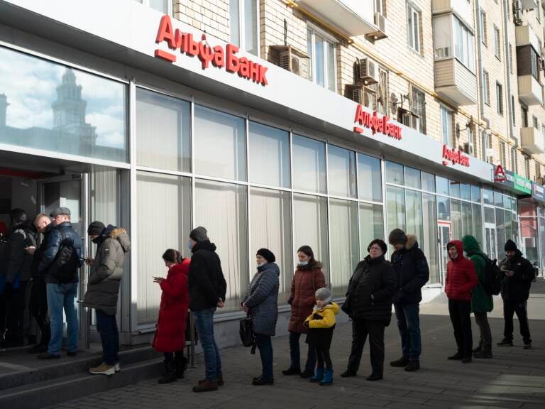 People stand in line to withdraw money from an ATM of Alfa Bank in Moscow