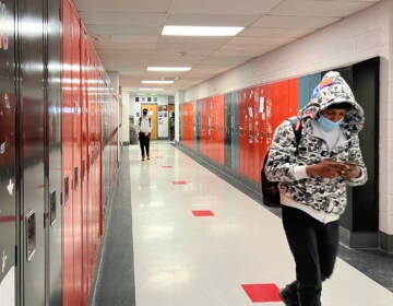 Students wear masks as they walk through a hallway at CAPA.