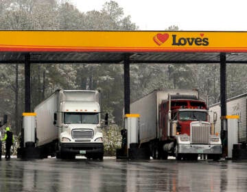 FILE - In this Feb. 11, 2014, file photo, truck drivers stop at a gas station in Emerson, Ga., north of metro Atlanta, to fill up their tractor trailer rigs. A new government rule being announced by the Federal Motor Carrier Safety Administration on Thursday, Dec. 10, 2015, requires an estimated 3 million commercial truck and bus drivers to electronically record their hours behind the wheel in an effort to enforce regulations to prevent fatigue. (AP Photo/David Tulis, File)