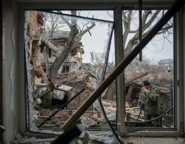 Andrey Goncharu wipes his face in the backyard of a damaged house