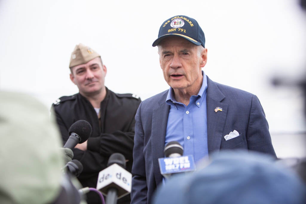 Senator Tom Carper speaks at a podium.