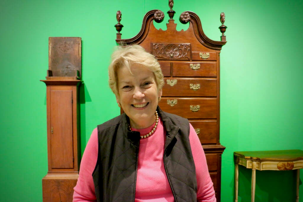 Eleanore Gadsden smiles for a portait in front of an antique