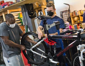 Eric Holte (left) learns to fix his bike with volunteer Michael Benko