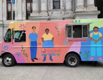 The hygiene truck, brightly colored, sits outside City Hall.