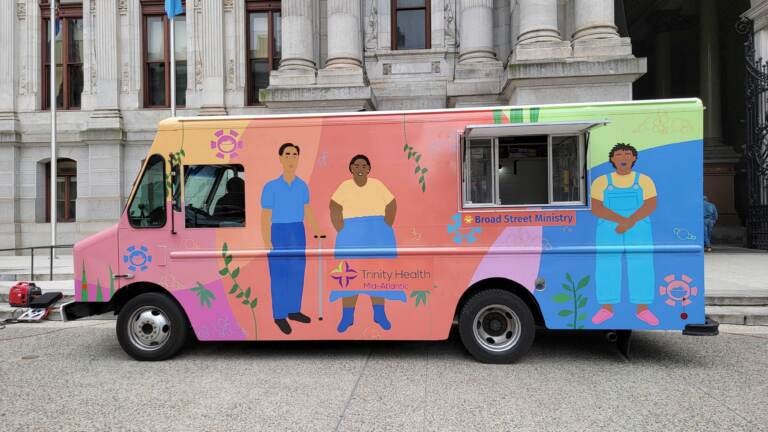 The hygiene truck, brightly colored, sits outside City Hall.