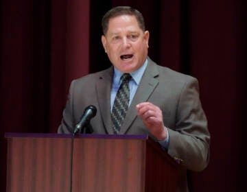 Dave White speaks from a podium during a debate