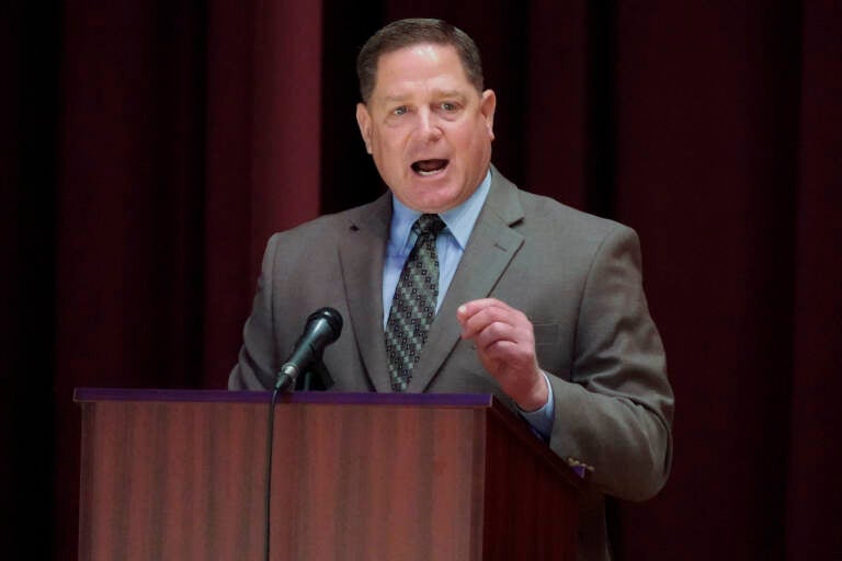 Dave White speaks from a podium during a debate