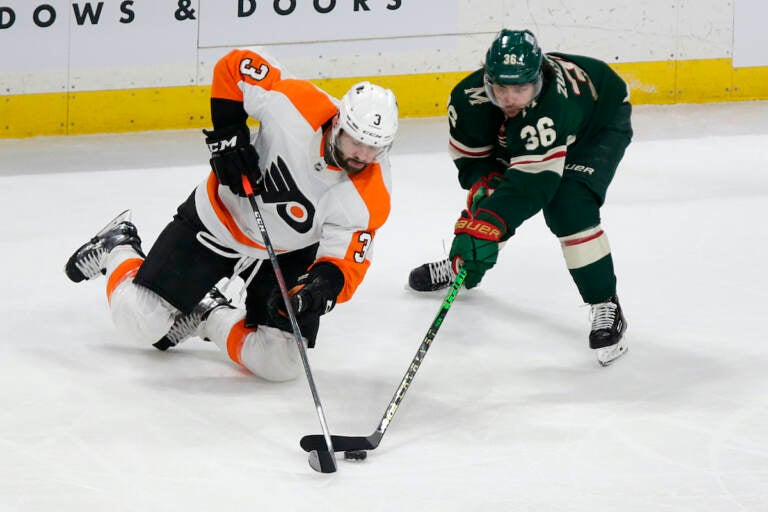 Philadelphia Flyers defenseman Keith Yandle (3) and Minnesota Wild right wing Mats Zuccarello (36) battle for the puck in the third period of an NHL hockey game Tuesday, March 29, 2022, in St. Paul, Minn. (AP Photo/Andy Clayton-King)