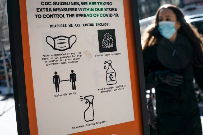 Pedestrians wearing protective masks walk along Broadway in the SoHo district of New York City, Friday, March 4, 2022, in New York. Mayor Eric Adams announced in a morning news conference that the city will be scaling back of COVID-19 mask and vaccine mandates