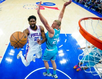 Philadelphia 76ers' Joel Embiid (left) goes up for the shot against Charlotte Hornets' Mason Plumlee, right, during the first half of an NBA basketball game, Saturday, April 2, 2022, in Philadelphia.