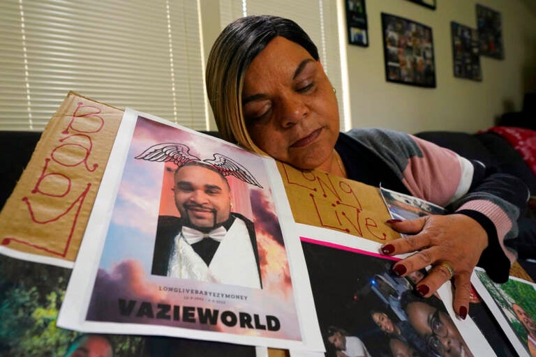 Penelope Scott holds a collection of family photos including one of her son, De'vazia Turner, one of the victims killed in a mass shooting, during an interview with The Associate Press in Elk Grove, Calif., Monday, April 4, 2022. Multiple people were killed and injured in the shooting a day earlier.