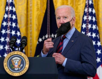 File photo: President Joe Biden takes off his mask as he arrives to speak about the coronavirus pandemic in the East Room of the White House in Washington, Tuesday, Aug. 3, 2021. (AP Photo/Susan Walsh)