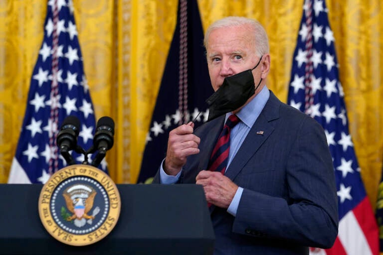 File photo: President Joe Biden takes off his mask as he arrives to speak about the coronavirus pandemic in the East Room of the White House in Washington, Tuesday, Aug. 3, 2021. (AP Photo/Susan Walsh)