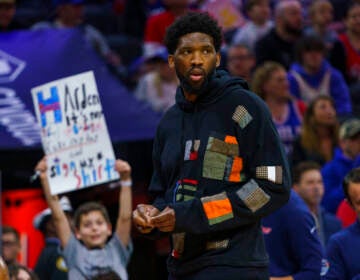 Philadelphia 76ers' Joel Embiid looks on as he has the night off during the first half of an NBA basketball game against the Detroit Pistons, Sunday, April 10, 2022, in Philadelphia.