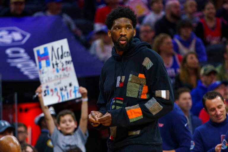 Philadelphia 76ers' Joel Embiid looks on as he has the night off during the first half of an NBA basketball game against the Detroit Pistons, Sunday, April 10, 2022, in Philadelphia.