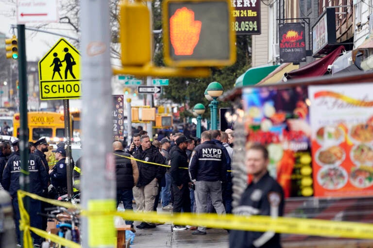 New York City Police Department personnel gather at the entrance to a subway stop in the Brooklyn borough of New York, Tuesday, April 12, 2022. (AP Photo/John Minchillo)